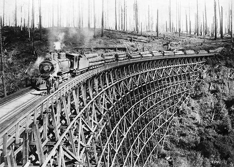 Steam train carrying lumber on a trestle bridge, Northern Pacific Railroad tributary.