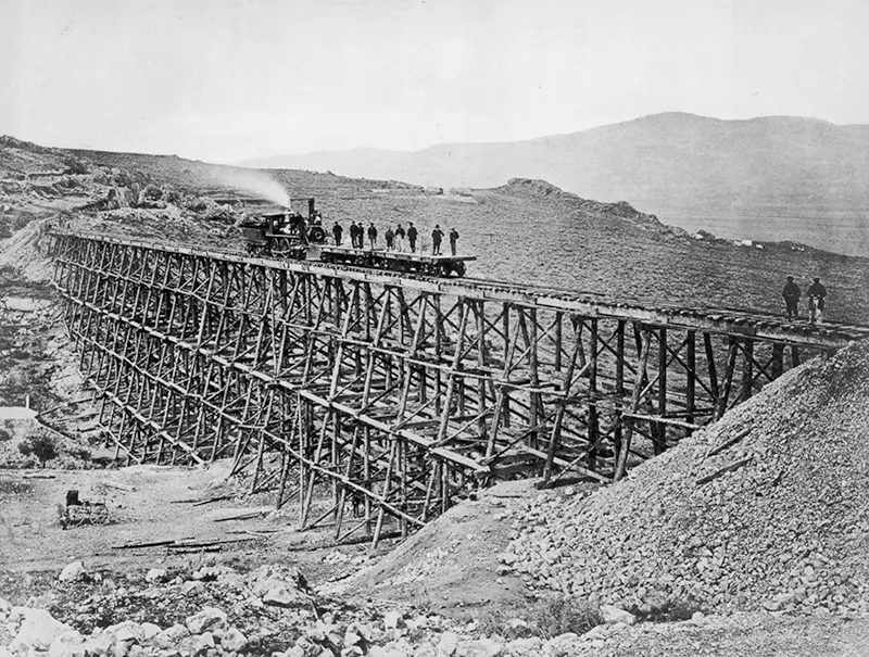 Locomotive engine testing a newly assembled railroad trestle.