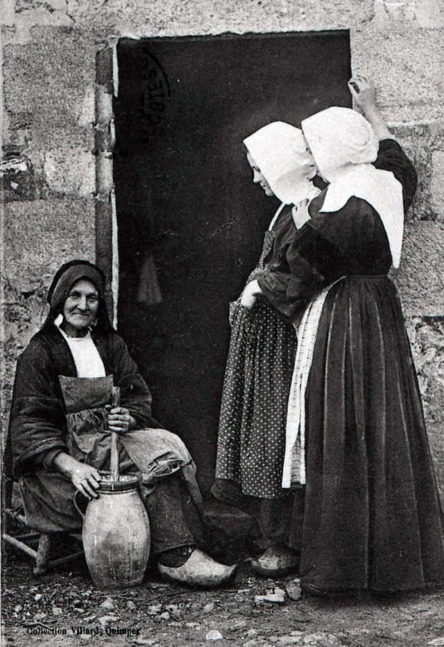 Breton peasant women making butter with a hand churn.