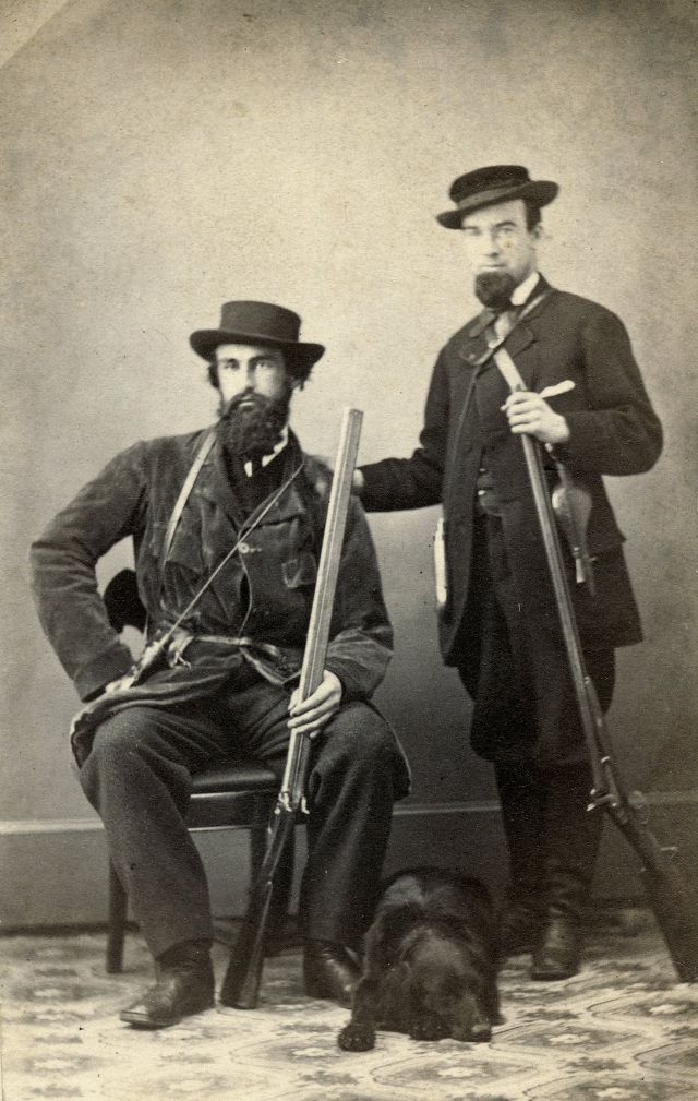 A pair of Keystone State hunters armed with double-barrel shotguns pose with their black Labrador Retriever