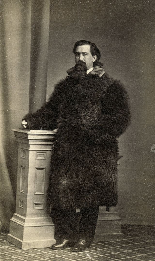 Man is dressed in a long robe made of a buffalo hide and a fur collar