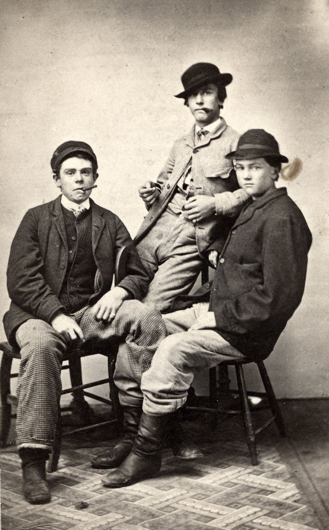 Three men pose for their likeness, two with cigars and one perhaps too young to have picked up the habit