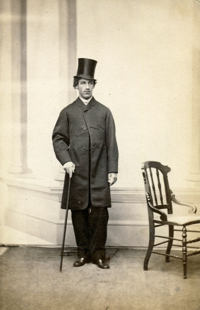 A Maine gentleman strikes a casual pose with frock coat, top hat and cane