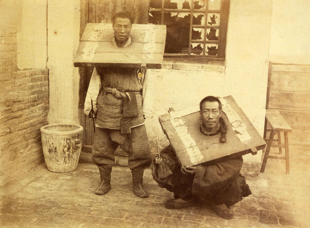 Chinese criminals restrained in wooden stocks.