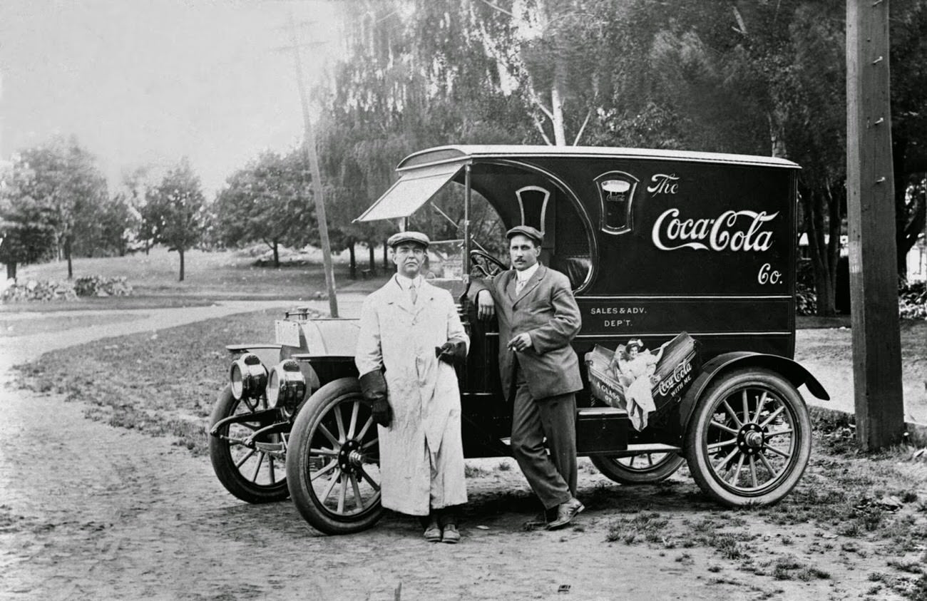 Two men standing by a Coca-Cola delivery truck, 1910.