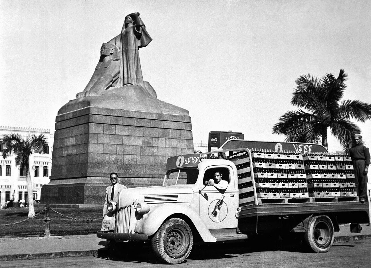 A a Coca-Cola delivery truck next to a statue in Egypt, 1950.