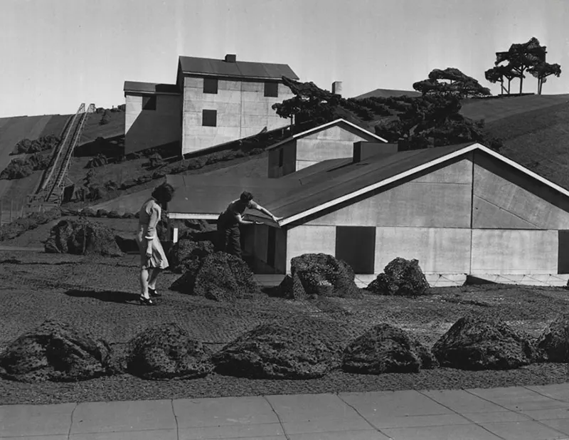 Suzette Lamoureaux and Vern Manion examining miniature bungalow in “Boeing Wonderland”.