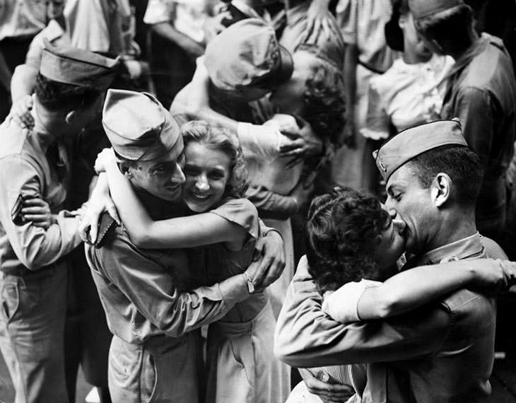 Servicemen and workers embrace and kiss, 1945.