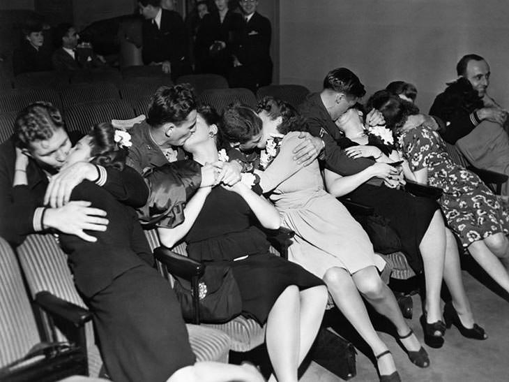 Husbands kiss wives after returning from war, 1940s.