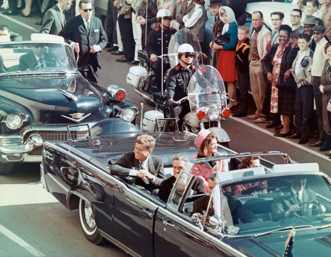 John F. Kennedy, First Lady Jacqueline Kennedy, Texas Governor John Connally, and others in a Dallas motorcade, minutes before the assassination, 1963.
