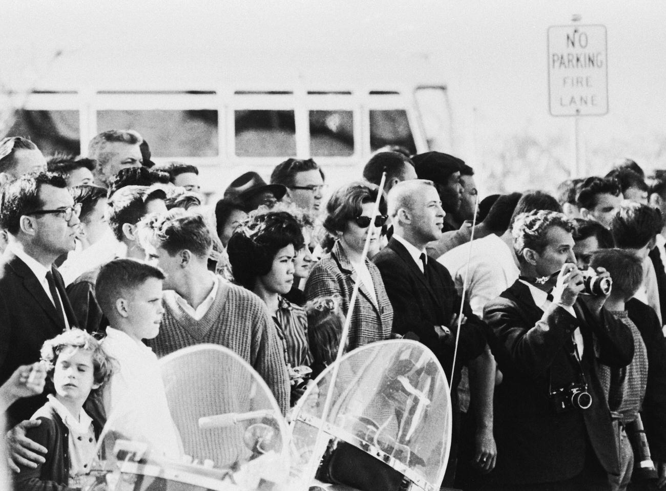 A crowd awaits President Kennedy's motorcade at Dealey Park in Dallas, Texas, just before his assassination.