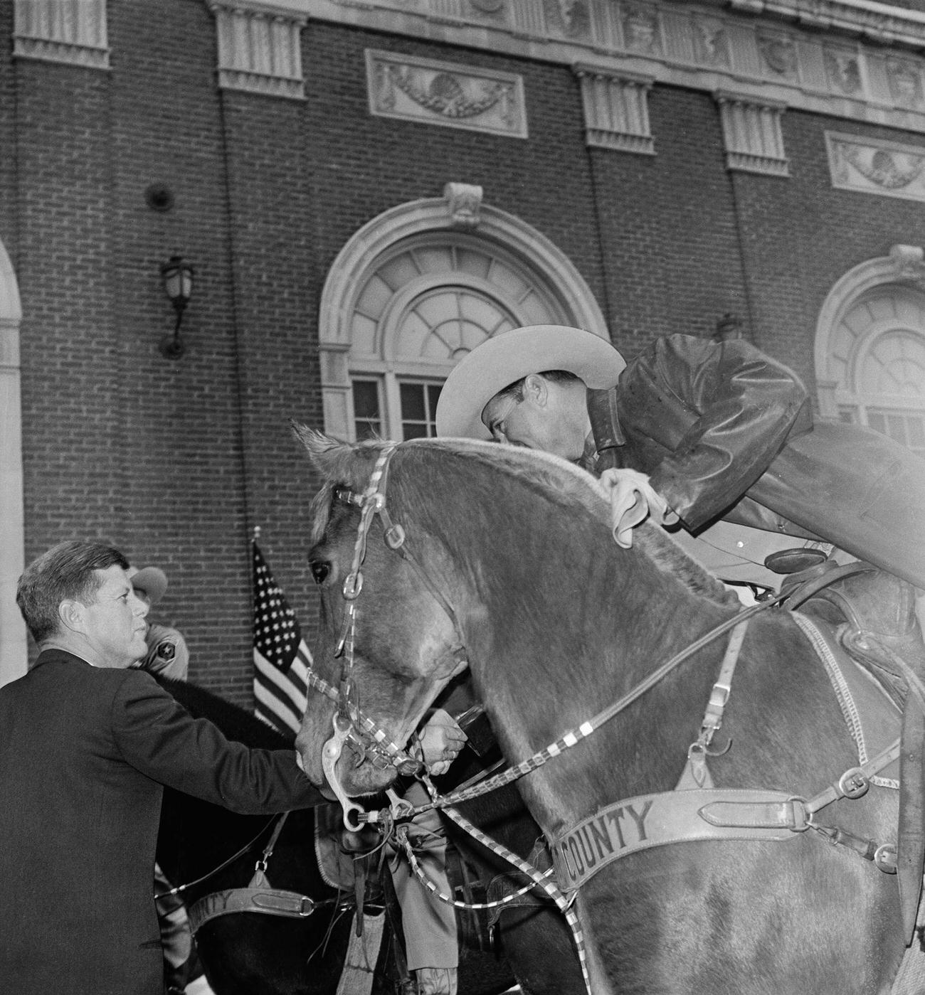 John F. Kennedy shakes hands with a mounted Tarrant County Sheriff's posse member after an outdoor speech, hours before his assassination in Dallas, 1963.