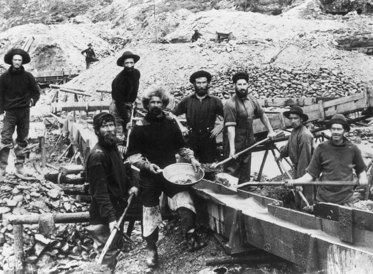 Jubilant miners displaying a large gold nugget during the Klondike Gold Rush, 1897.