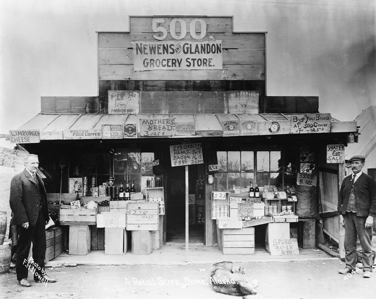 The Newens and Glandon grocery store in Nome, Alaska, displaying a "Water for Sale" sign during the Klondike Gold Rush.