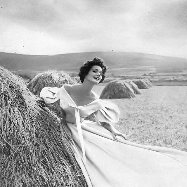 Linda Harper in a fog-gray faille dinner dress with pleated pillow sleeves by Sybil Connolly, Ireland, 1953.