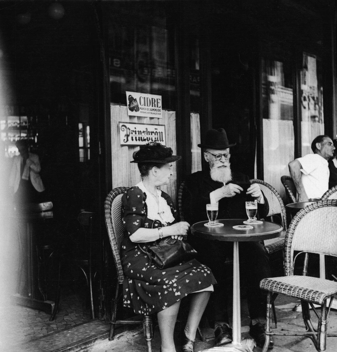 Elderly European Couple Enjoying Beer at a Sidewalk Cafe in Paris, 1930s