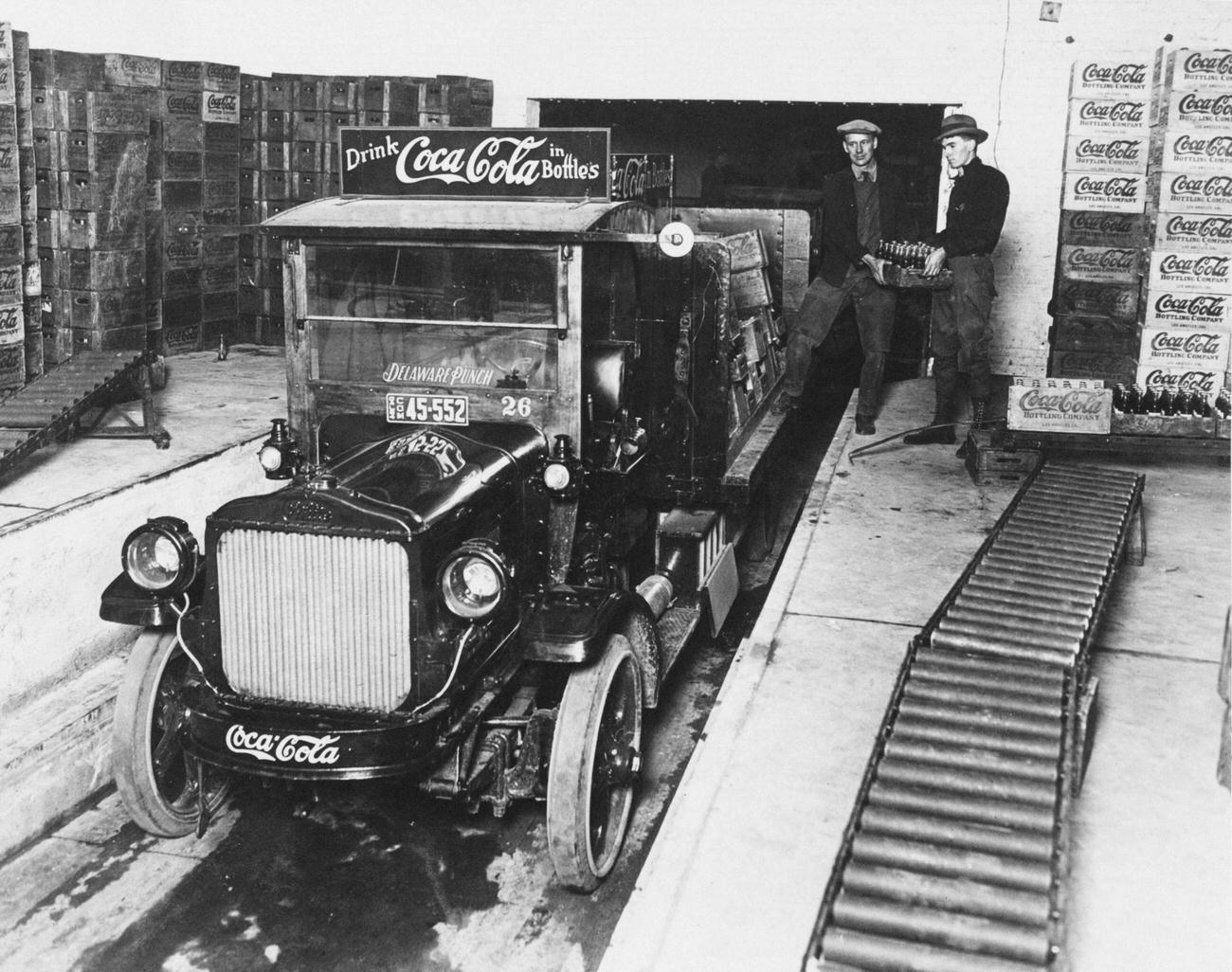 Workers loading crates of Coca-Cola onto a truck, circa 1930.