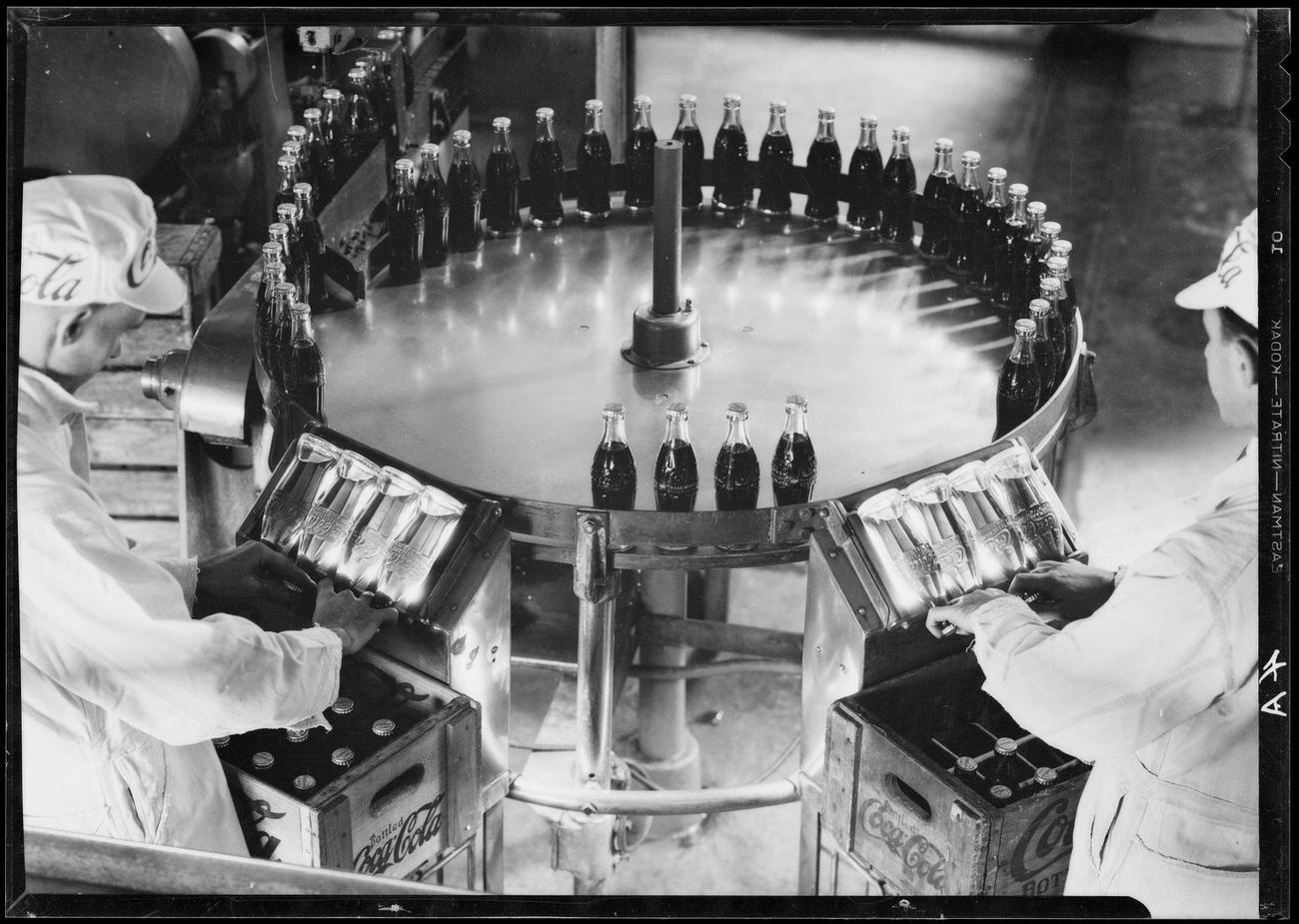 Men inspecting bottles at a Coca-Cola plant in Los Angeles.