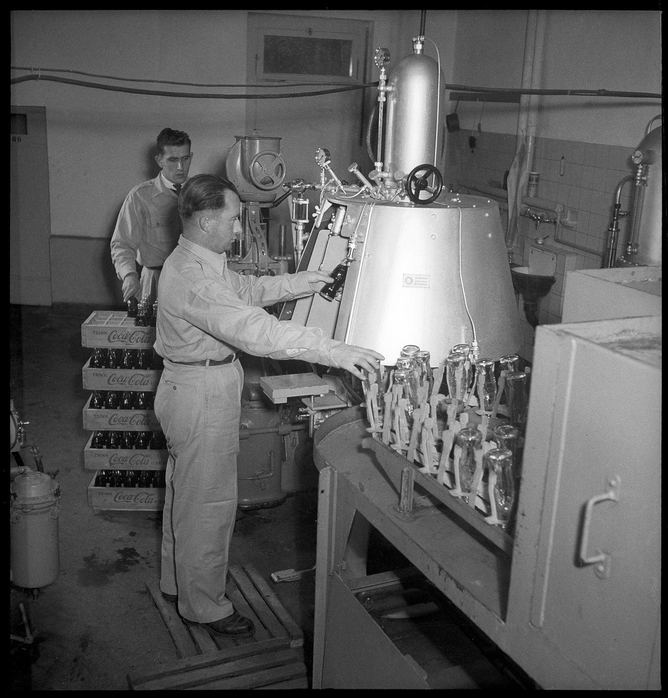 Coca-Cola worker at a bottling plant with a bottle, 1949.