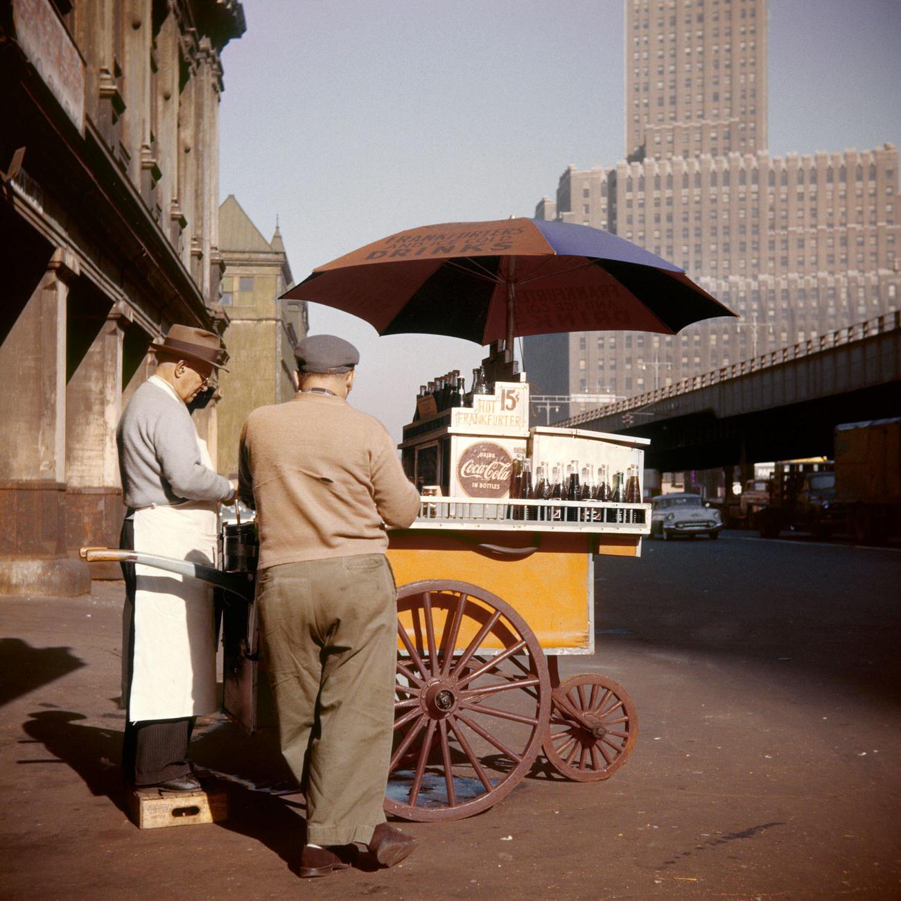 1950s hot dog vendor in downtown Manhattan, New York, USA, selling Cokes.