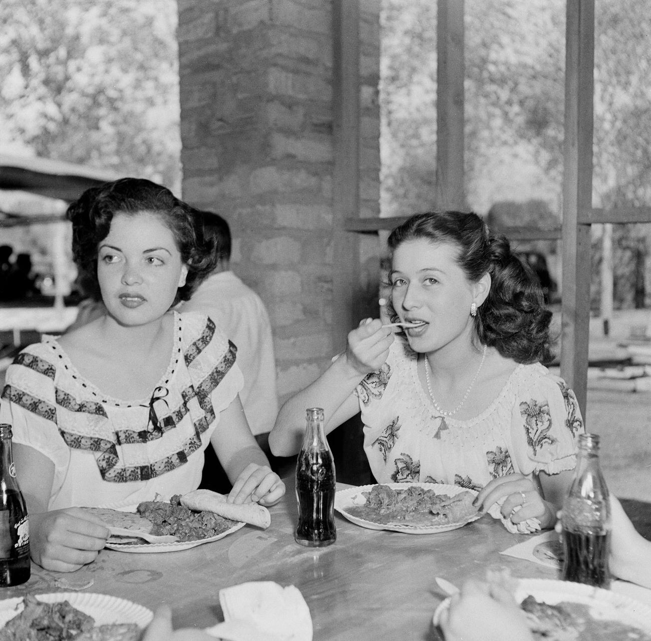 Two Mexican girls at lunch during a festival in Tijuana, Mexico, March 15, 1950.