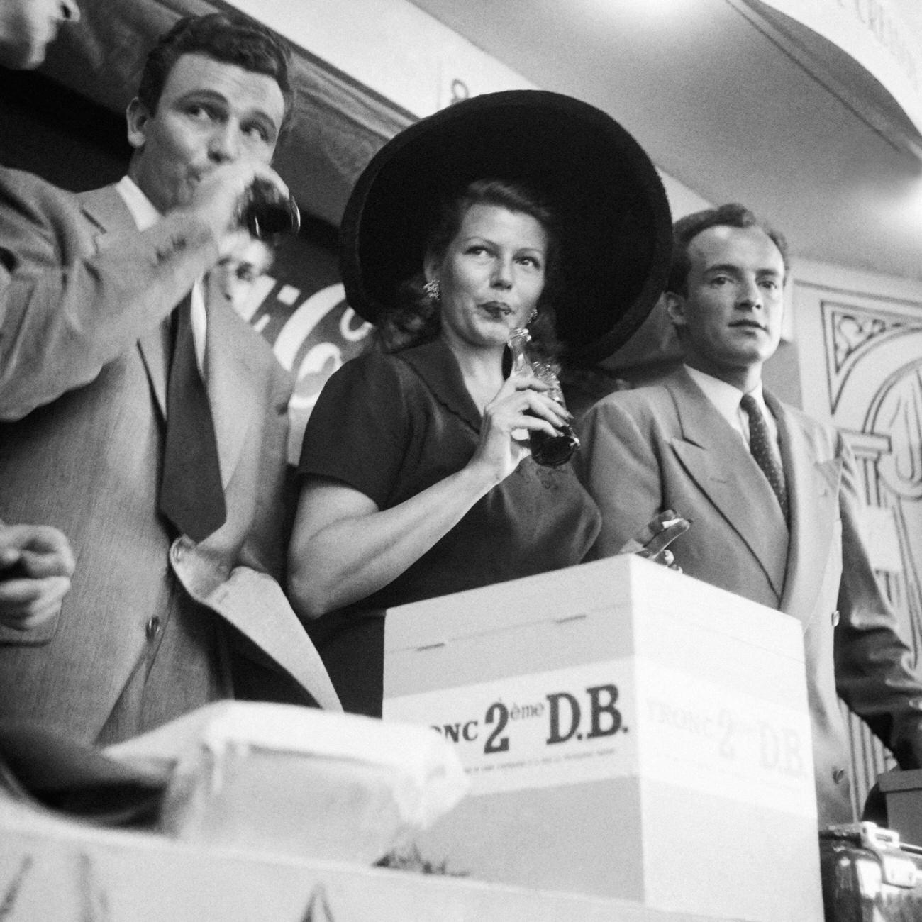 Actress Rita Hayworth drinking Coca-Cola at a fair in Paris, June 10, 1950.