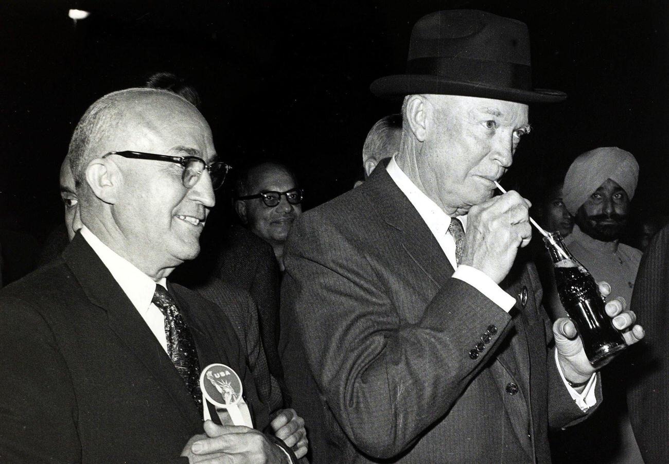 President Dwight D. Eisenhower enjoying Coca-Cola at an exhibition in New Delhi, India, 1959.