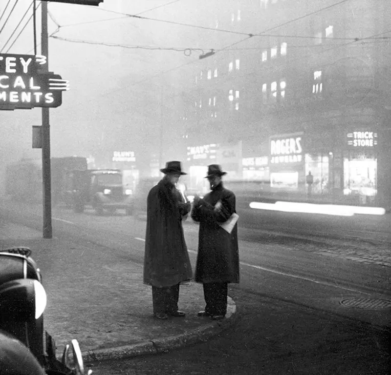 Two businessmen smoking cigarettes on Liberty and Fifth Avenues, busy street scene.