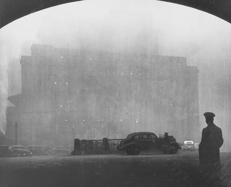 Silhouetted man in hat against a smoky traffic scene near Downtown and Liberty Avenue.