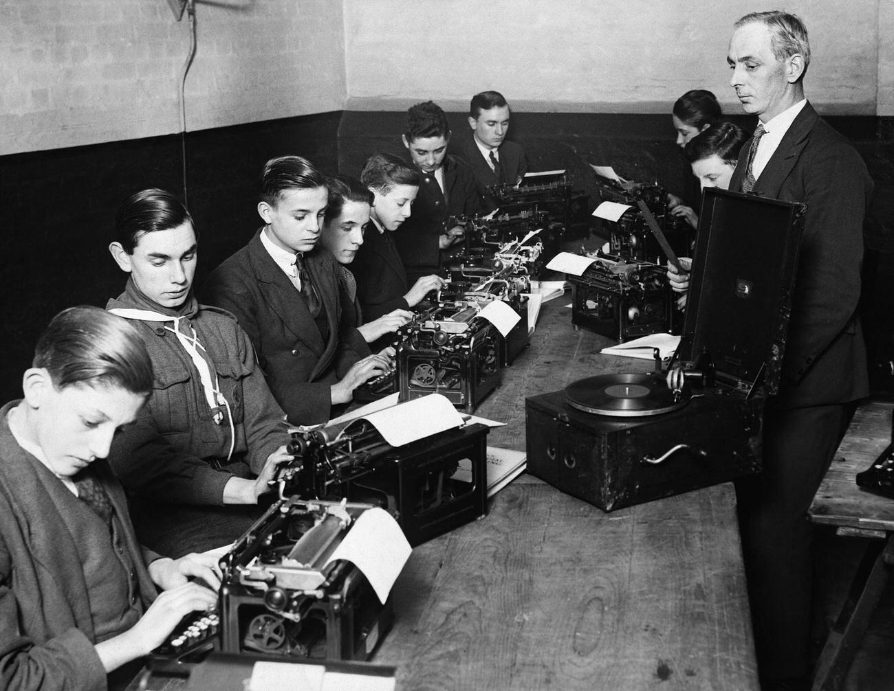 Newspaper messenger boys typing to rhythm of a record, Keeley Street Evening Institute.