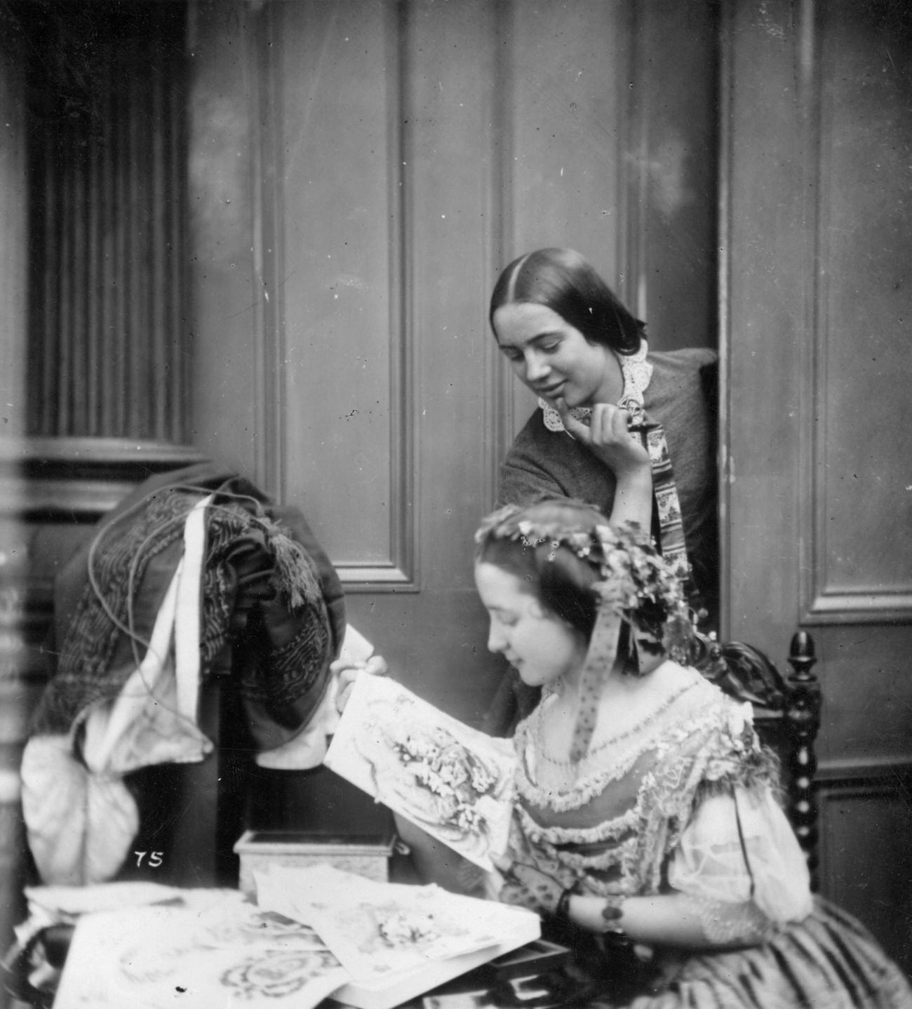 Two Victorian women admiring Valentine cards, circa 1860.