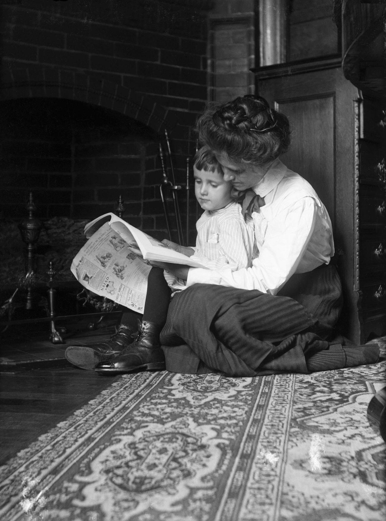 Victorian mother and child reading by a fireplace, 1890.