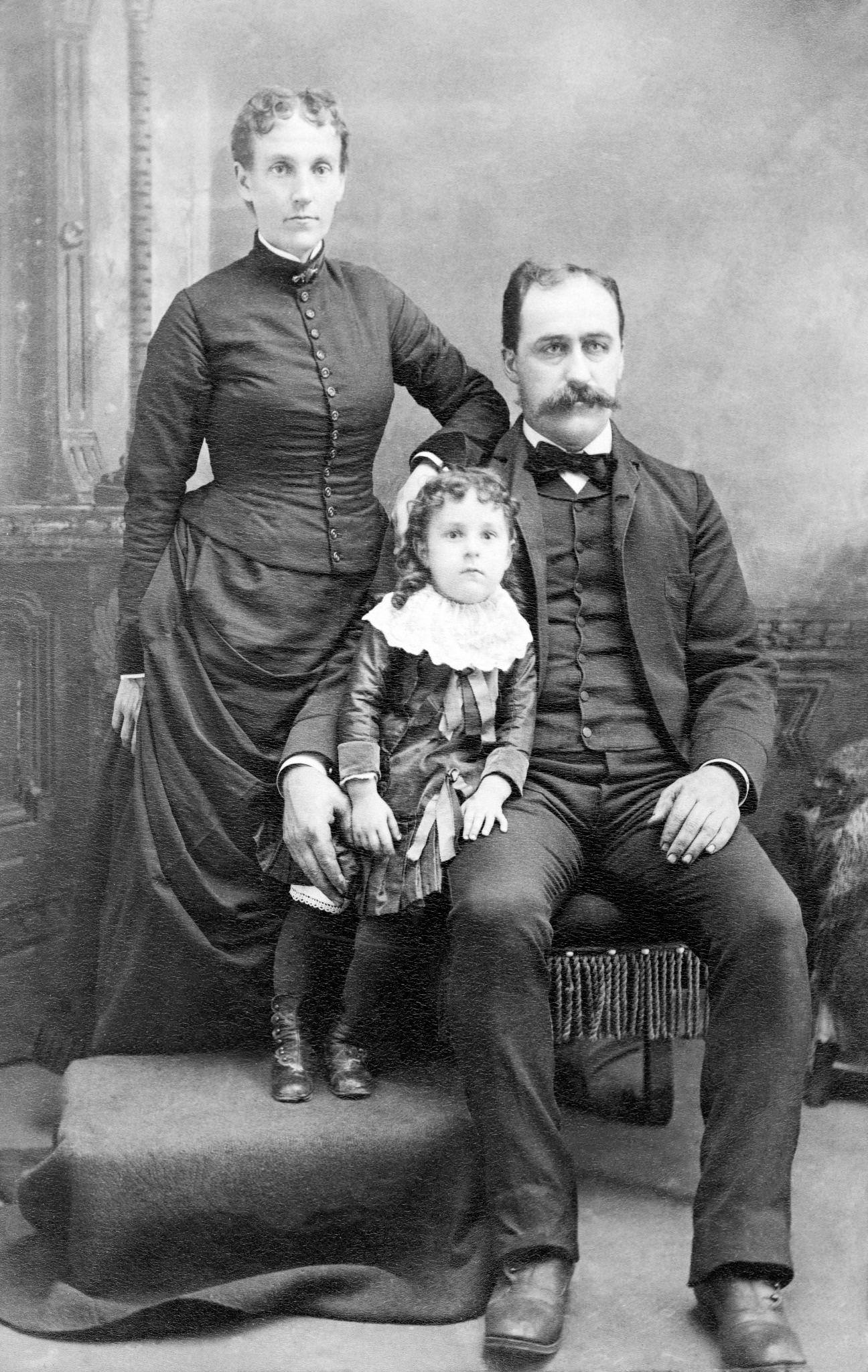 Victorian family with a child in a studio portrait, 1890s.