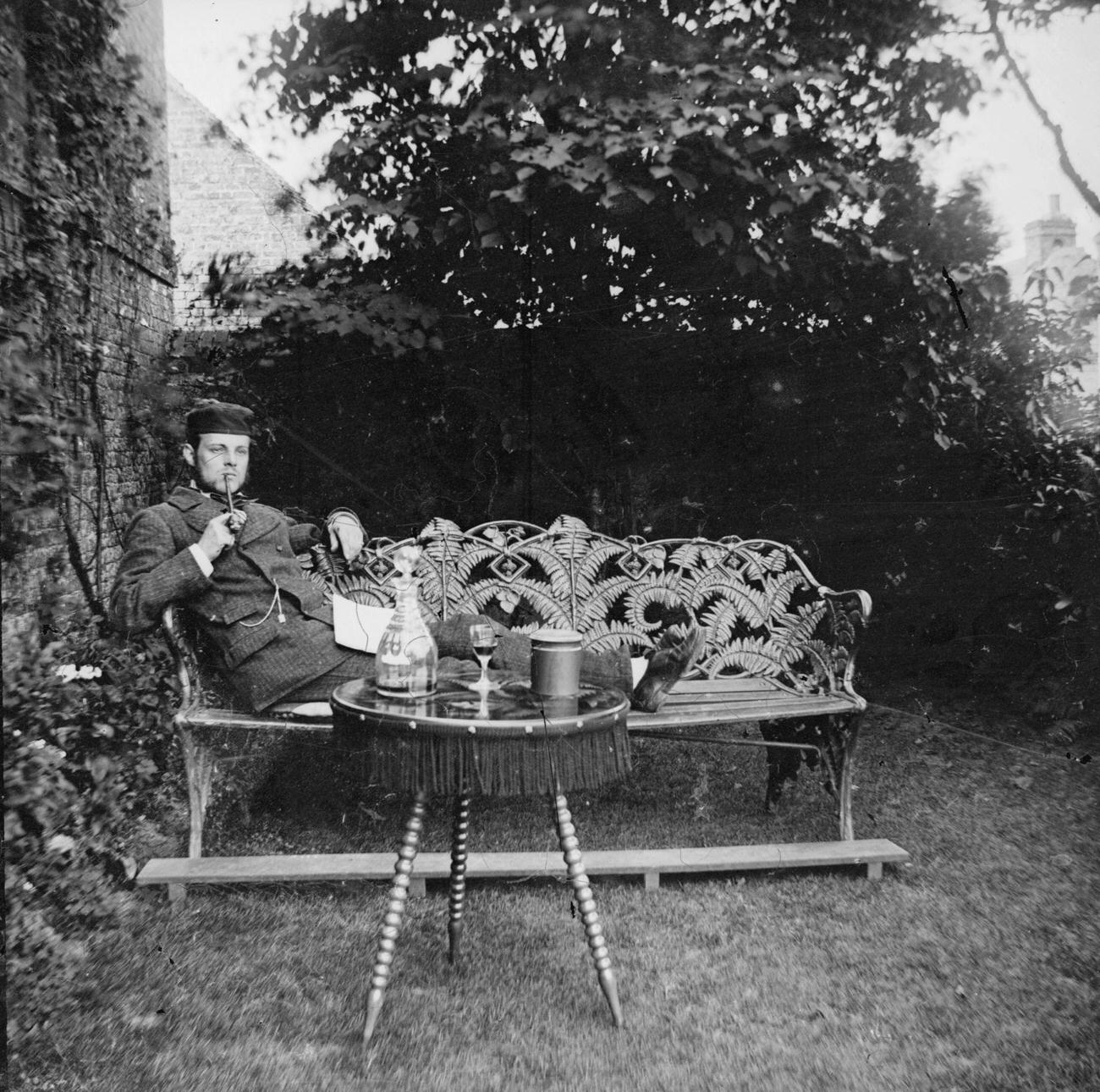 A Victorian gentleman relaxing in his garden, circa 1895.