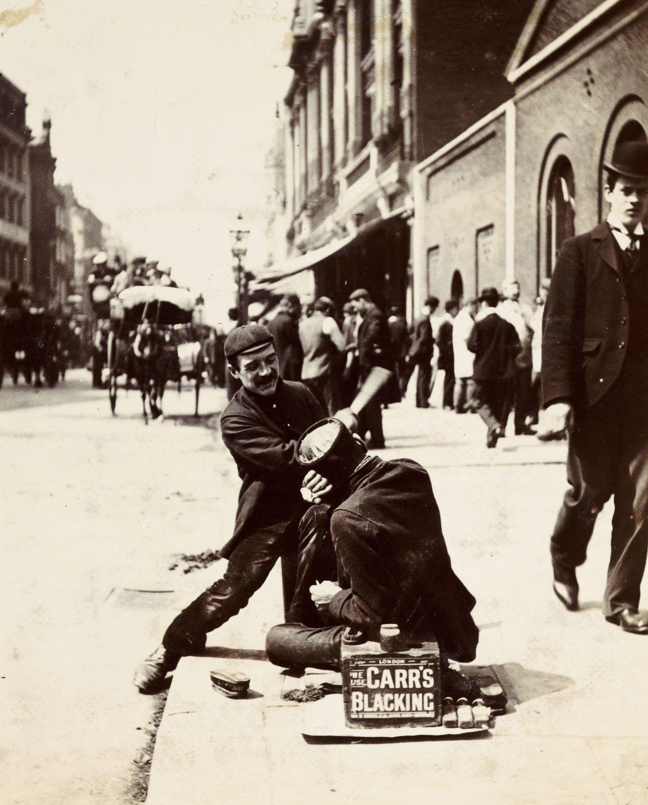 Two bootblacks working, circa 1895.