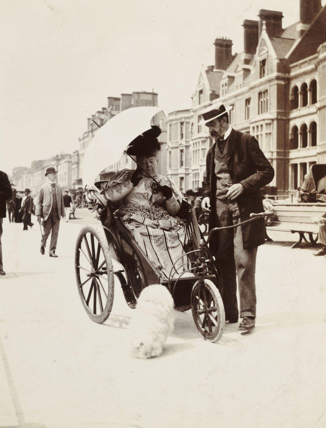 Woman in a bathchair on a seafront parade, circa 1900.