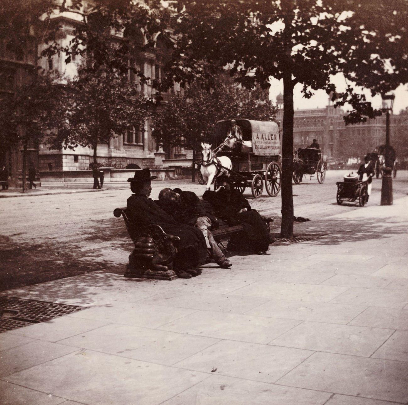 London street scene with people resting on a bench, circa 1900.