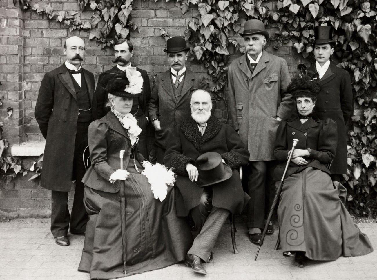 Victorian group posing in a garden, circa 1900.