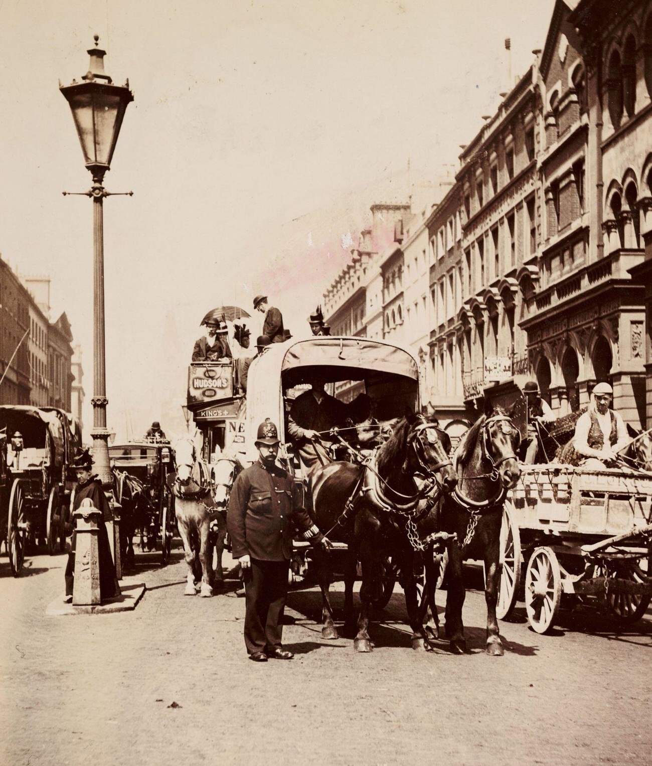 Policeman directing horse-drawn traffic in London, circa 1900.