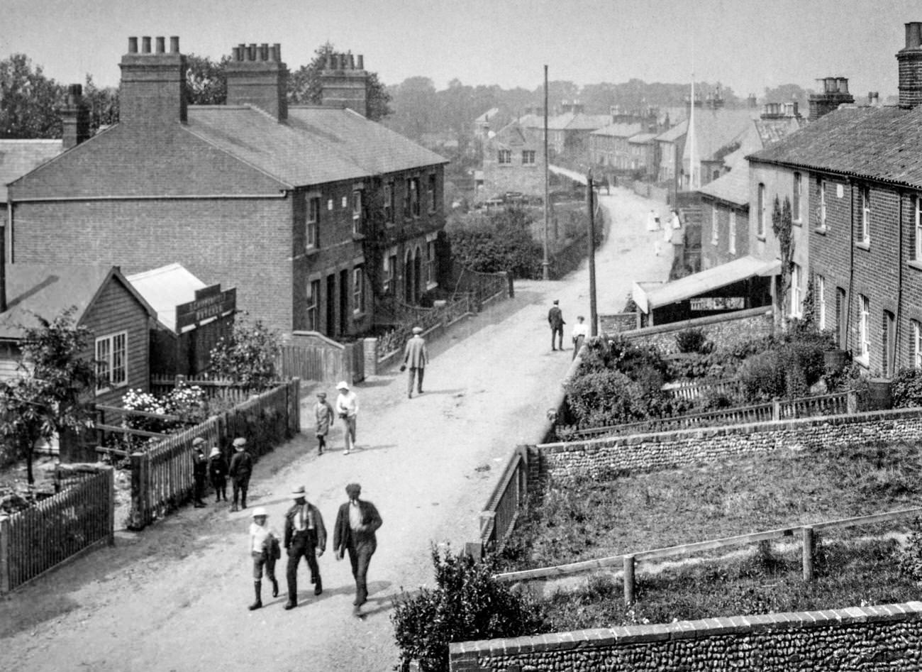 Typical street scene with children and a butcher's shop, circa 1900.