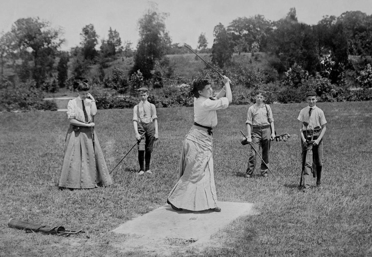 Golfing party with women and boy caddies, circa 1910.