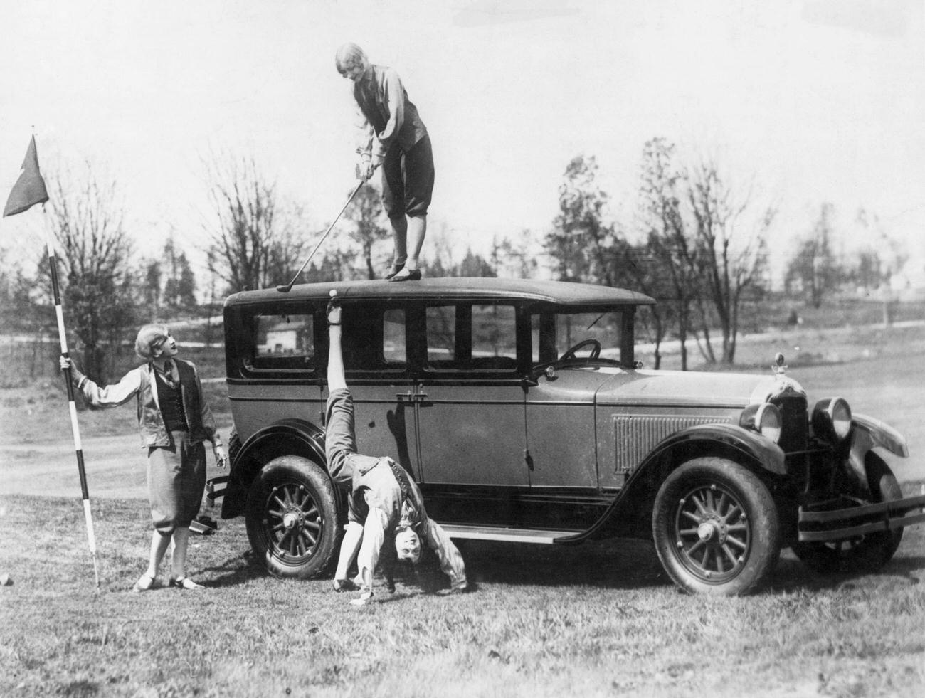 Woman hitting golf ball off another woman's foot, 1927.