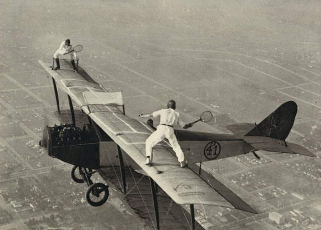 Black Catters Ivan “Bugs” Unger and Gladys Roy enjoy a game of tennis on the upper wing of a Curtiss Jenny.