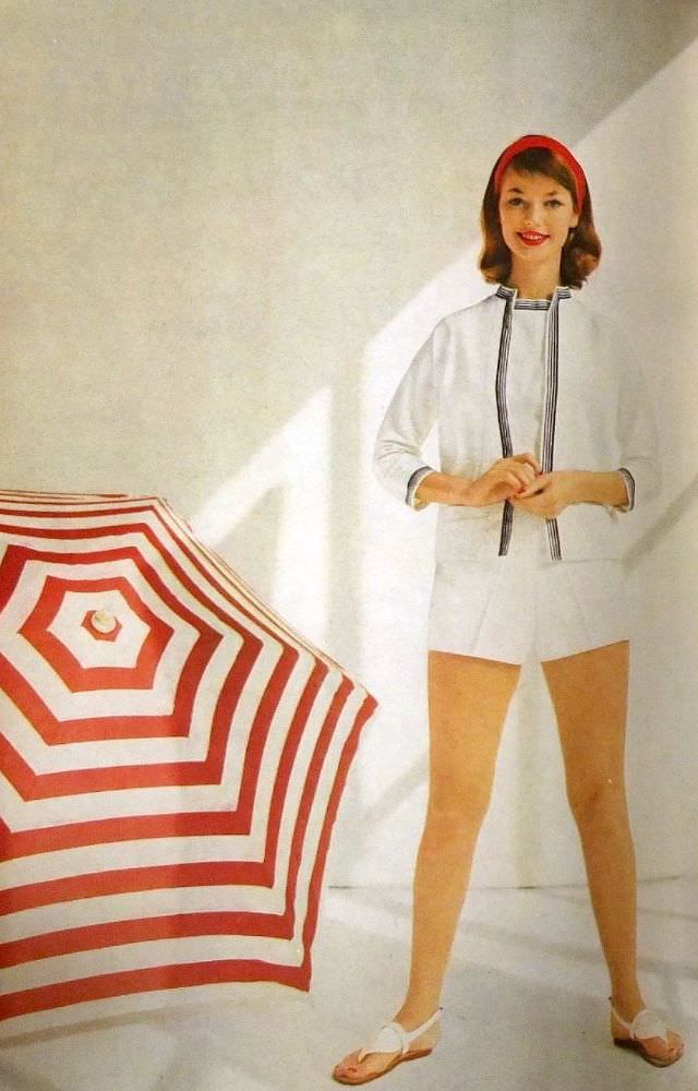 Dolores Hawkins in summery white piqué shorts and sleeveless top with navy-trimmed jacket by Jo Collins, 1956.
