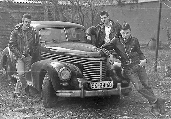 Greasers lounging by a car.