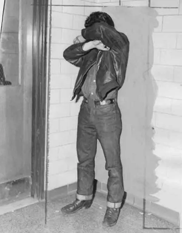 Teen in 1954, hiding his face from the camera.