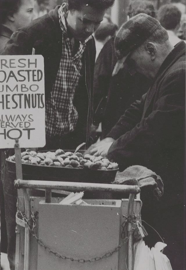 Food vendor grabbing roasted chestnuts, November 1957