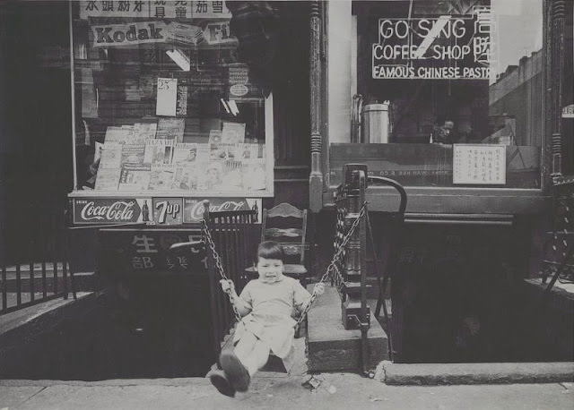 Young girl swinging outside of Go Sing Coffee Shop, September 1958