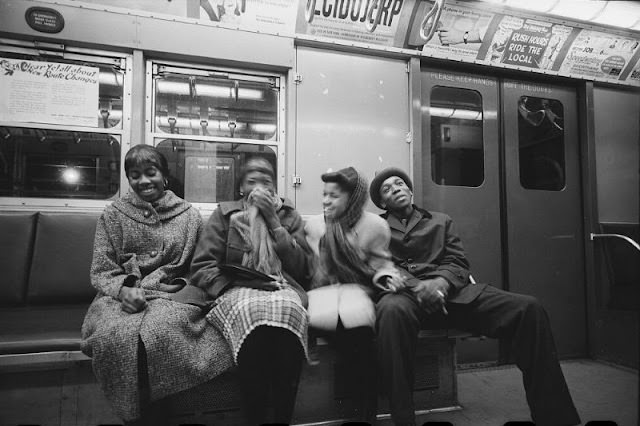 African American young people sharing a laugh while riding the subway, February 1959
