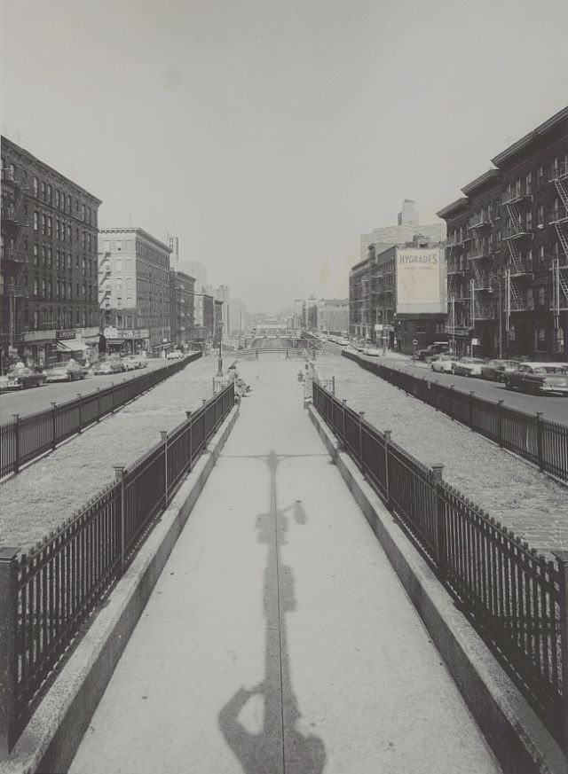 Park Avenue between 96th-97th Street - detail view of gated traffic median with people seated on benches, train tracks in background, October 1959